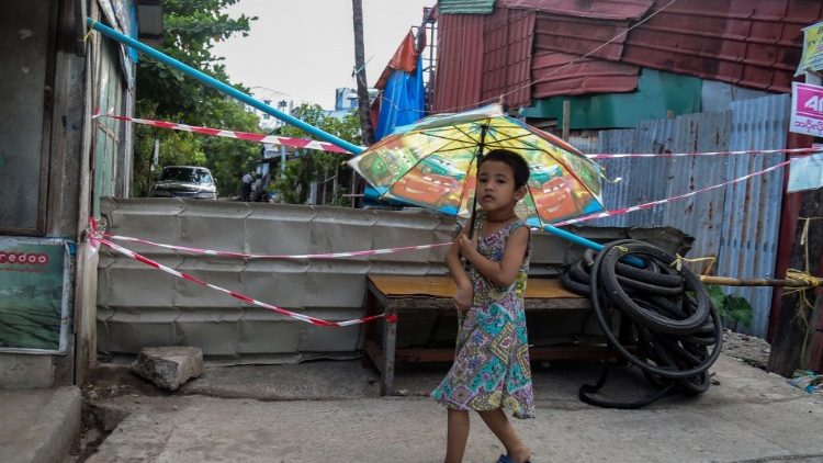 Menina próxima a uma barricada na periferia de Yangon