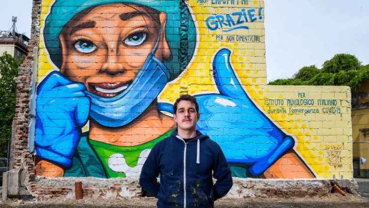 Artista Lapo Fatai posa delante de su mural en honor a los médicos que luchan contra el Covid-19, Milán.