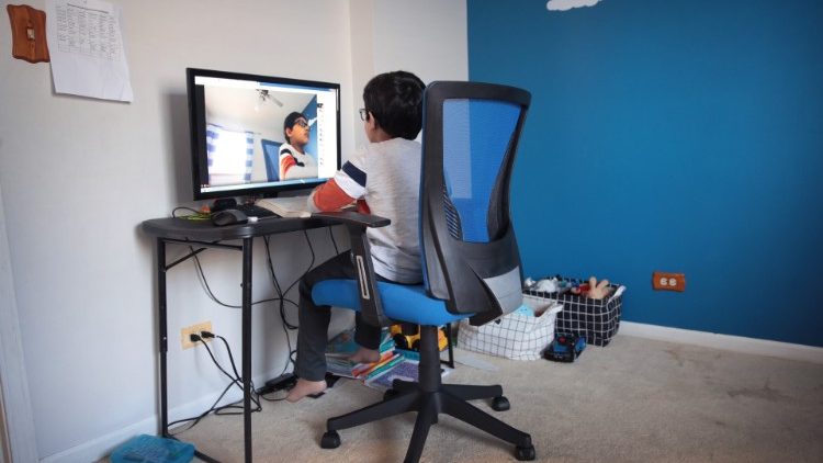 A child participating in an e-learning class from home. 