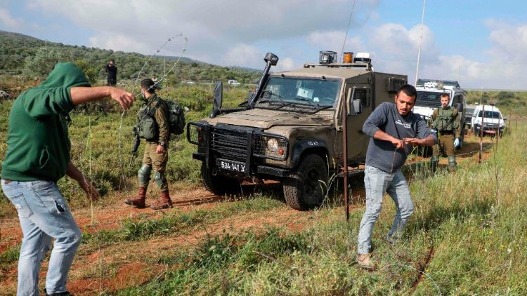 Palästinenser versuchen, den Stacheldraht zu entfernen, mit dem jüdische Siedler im Westjordanland besetzte Gebiete eingezäunt haben