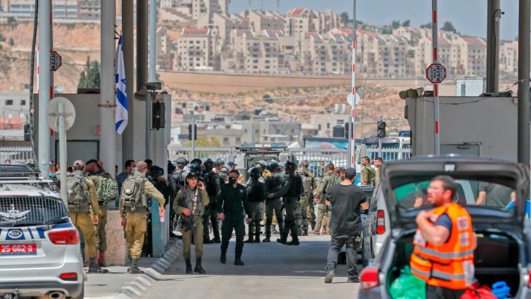 Soldados israelíes se reúnen en el sitio de un ataque punzante en el puesto de control de Qalandia controlado por Israel en Cisjordania ocupada.