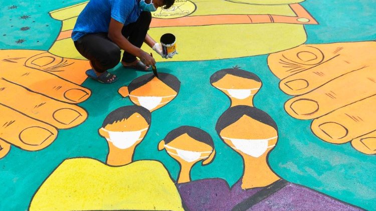Artista pinta mural em agradecimento aos profissionais de saúde em Mumbai