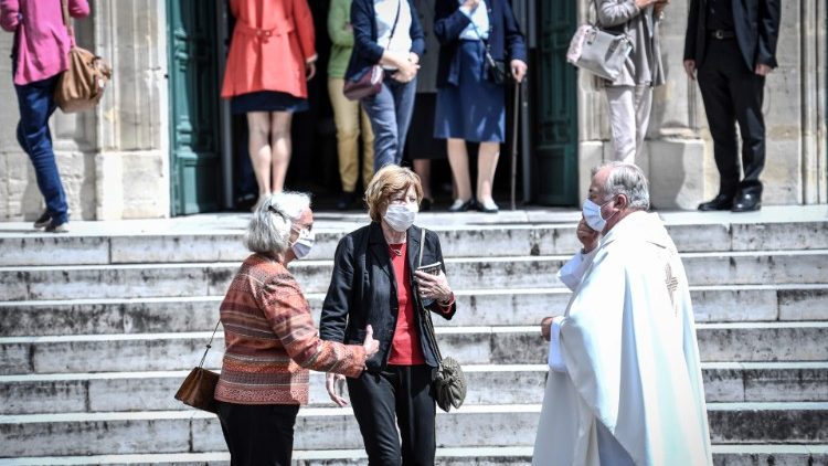 Un prêtre salue les fidèles à la sortie de l'église Saint-Jean-Baptiste de Neuilly-sur-Seine, le 23 mai 2020.