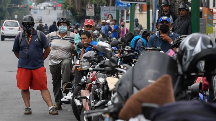 Motorradfahrer warten an einer Tankstelle in Caracas auf das (knapp gewordene) Benzin