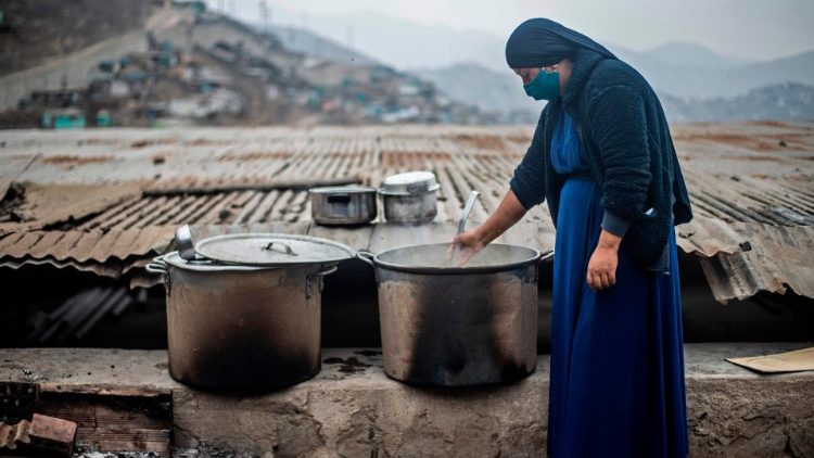 A nun stirs a pot at a soup kitchen in Lima, Peru