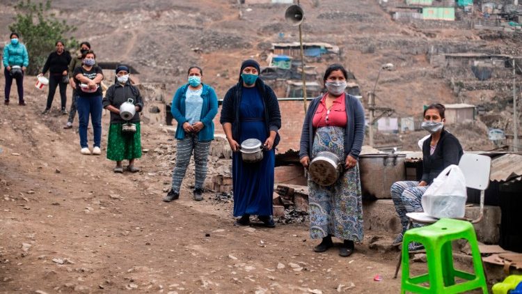 Mujeres esperan su turno para llenar sus cacerolas con comida, Perú. 