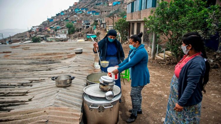 Une religieuse sert de la nourriture à des personnes démunies dans un quartier sud de Lima