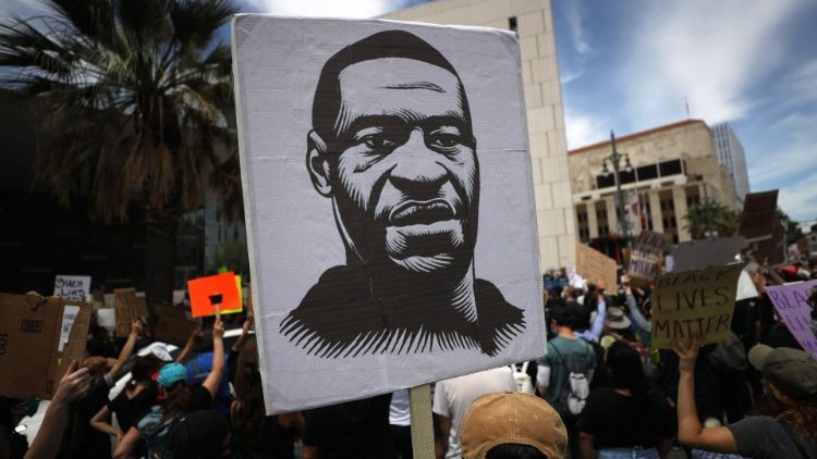 Protesters in Los Angeles hold a sign with an image of George Floyd
