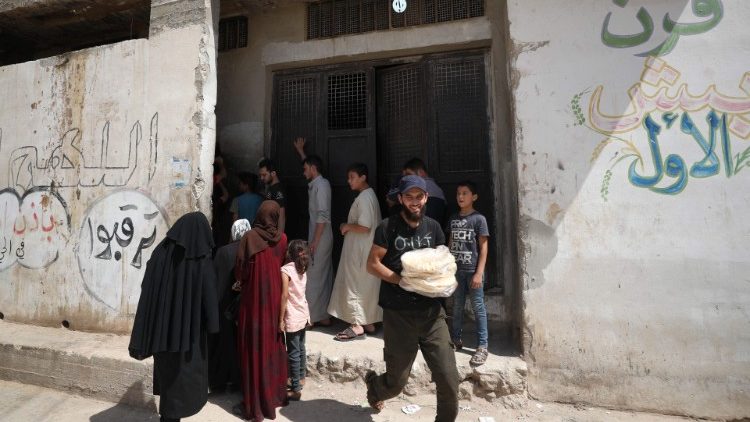 Syrians buy bread in Idlib province, on the third day of anti-regime protests