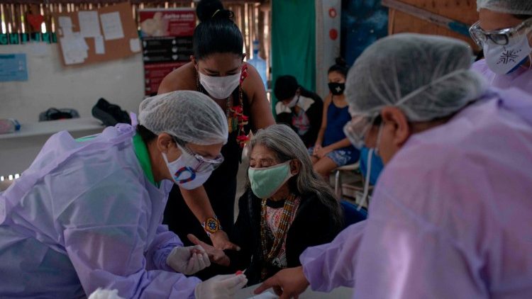 ब्राज़ील में स्वास्थ्य कर्मी कोविद-19 रोगियो की मदद करते हुए