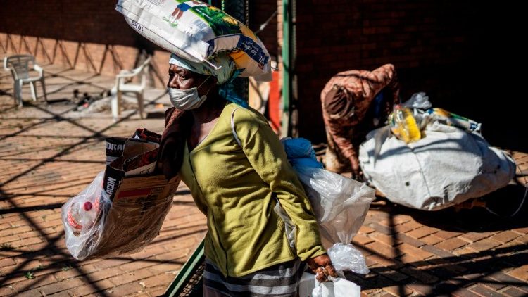 A woman in South Africa's Gauteng province carries a food parcel distributed by a Charity