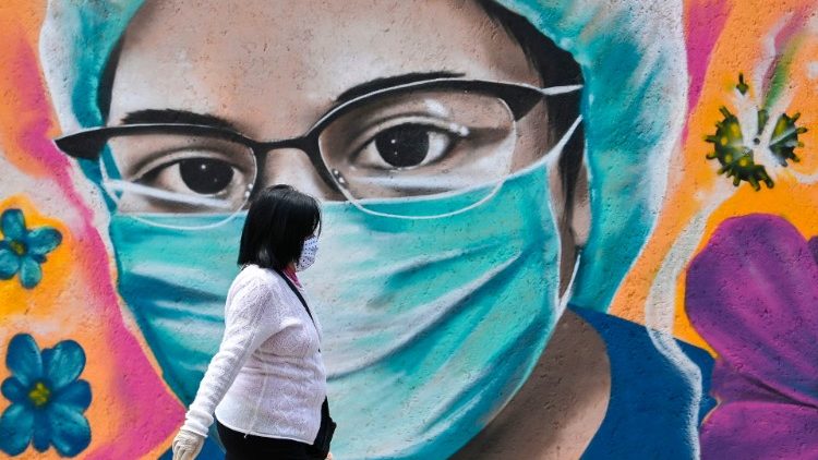 Une femme dans une rue de Mexico, devant une peinture murale dédiée au personnel soignant face à la pandémie, le 15 juillet 2020