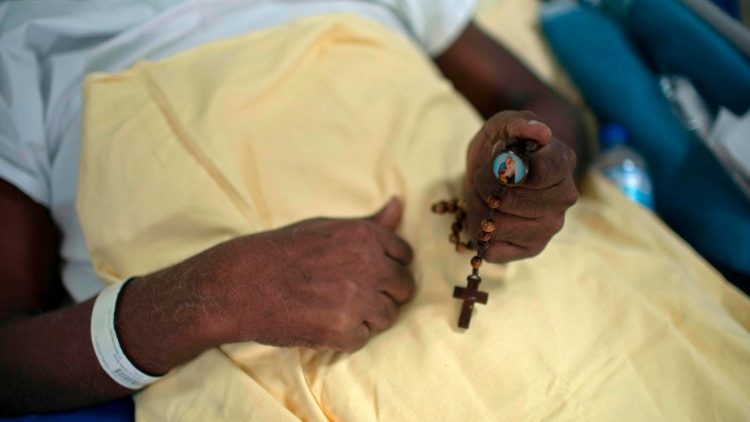 Ar Covid-19 slims cilvēks lūdzas Rožukroni (slimnīca Riodežaneiro, Brazīlijā, 2020. gada jūlijs)