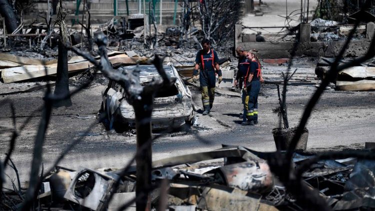 Firefighters examine the site of a fire near Marseille
