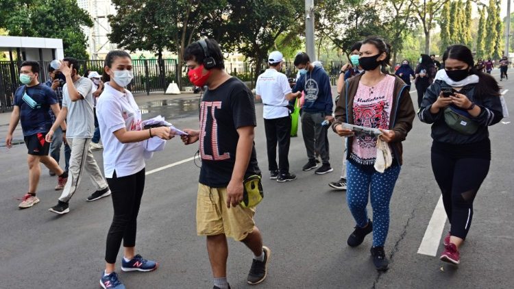 Eine Freiwillige verteilt an diesem Montag in Jakarta Gesichtsmasken