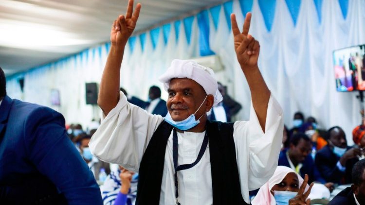 At the signing ceremony of the Sudan peace deal held, Monday, in Juba, South Sudan, a man makes the peace sign