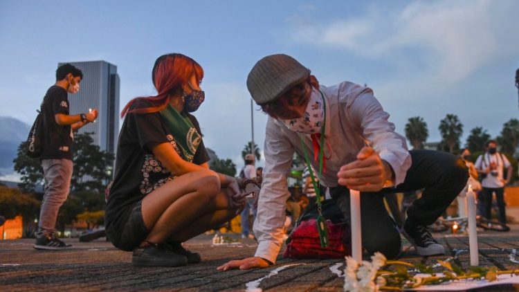 Pessoas acendem velas durante protestos contra a violência no início deste mês