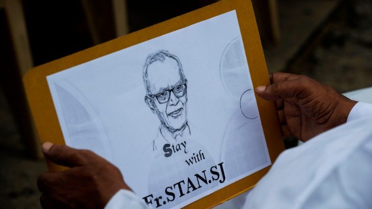 Ein katholischer Priester hält ein Plakat mit dem Bild des Jesuitenpaters Pater Stan Swamy während eines Protests gegen seine Verhaftung.