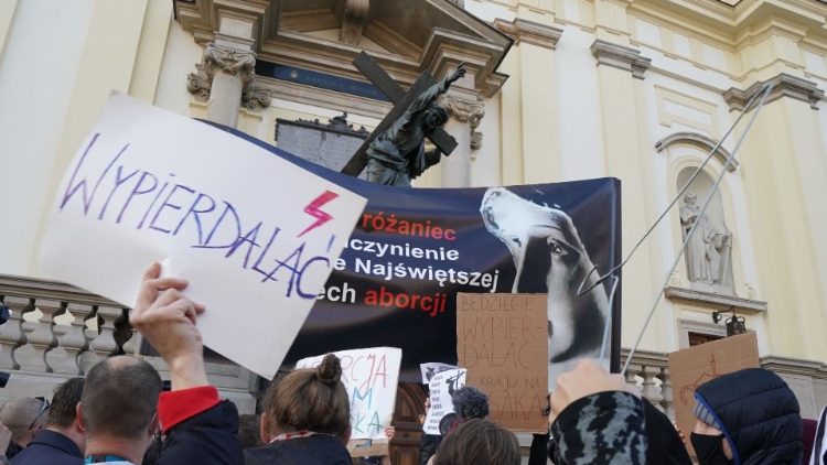 Manifestantes diante de igreja em Varsóvia