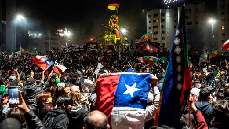 Manifestantes que apoyan la reforma de la constitución chilena celebran mientras esperan los resultados oficiales del referéndum en la Plaza Italia de Santiago el 25 de octubre de 2020
