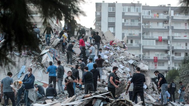 Voluntários escavam em busca de sobreviventes após desabamento de um prédio na Turquia provocado pelo sismo