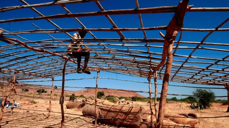 An Ethiopian refugee sets up a tent in neighboring Sudan