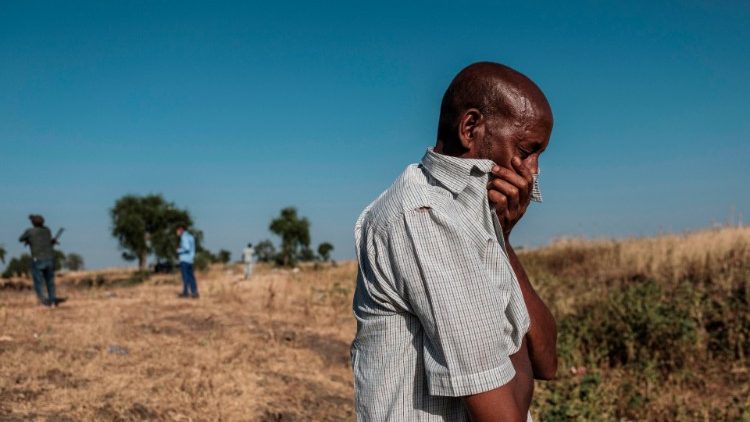 A man cries over a mass grave near Mai Kadra, Ethiopia