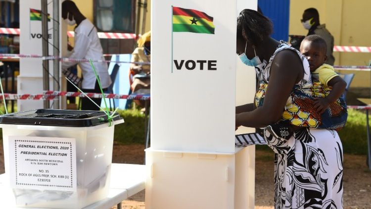 A Ghanaian woman carries her child on her back as she casts her vote 