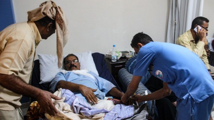 Health care workers care for a man wounded in an attack on the airport in Aden, Yemen, on Wednesday