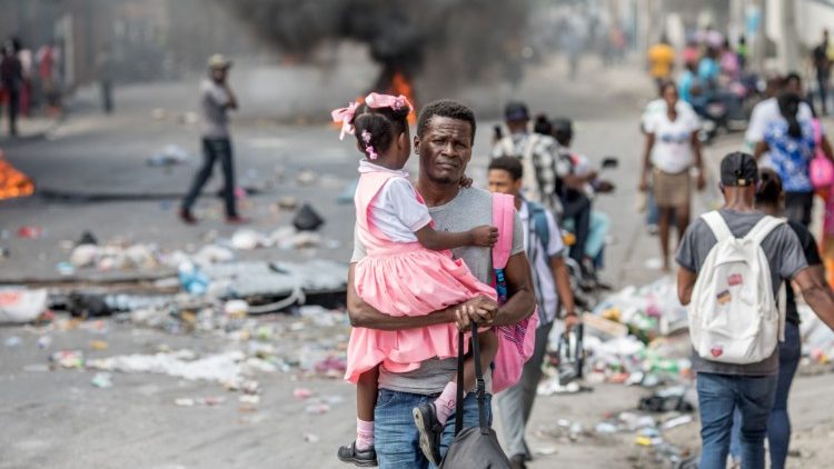 Una padre haitiano con su hija por las calles de Haití en medio de las protestas.