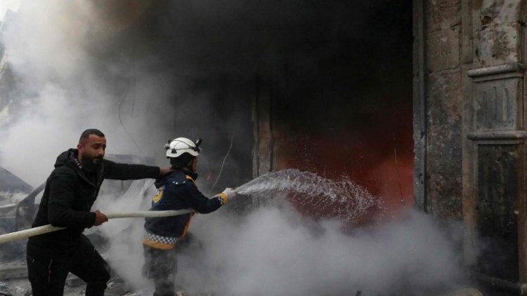 Rescue workers try to extinguish a fire caused by an explosion in the town of Azaz, Syria