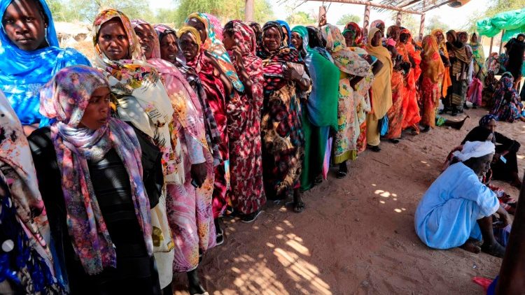 Frauen warten im Flüchtlingslager Otash auf die Lebensmittellieferungen durch das World Food Programme