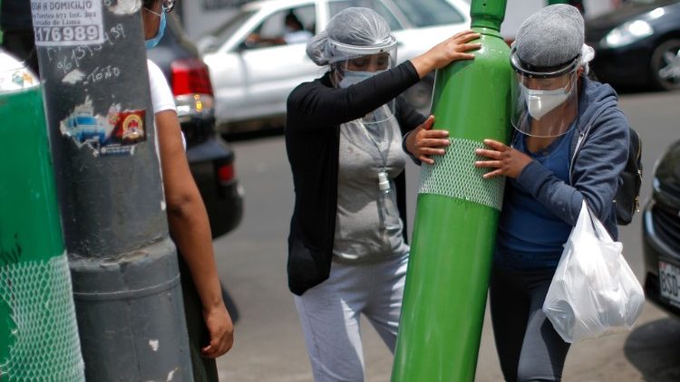 Peru. Članovi obitelji oboljelih odnose boce napunjene kisikom