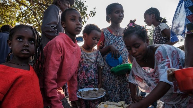 Vertriebene Kinder aus West-Tigray versammeln sich zur Essenszeit vor einem Klassenzimmer der Schule, in der sie untergebracht sind, in Tigrays Hauptstadt Mekele am 24. Februar 2021, um Teller mit Essen zu erhalten.