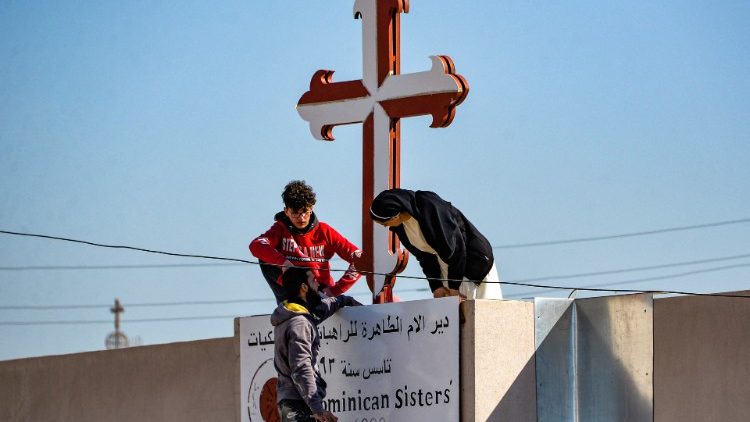 Christians in Iraq repair a cross in Qaraqosh, in Nineveh province