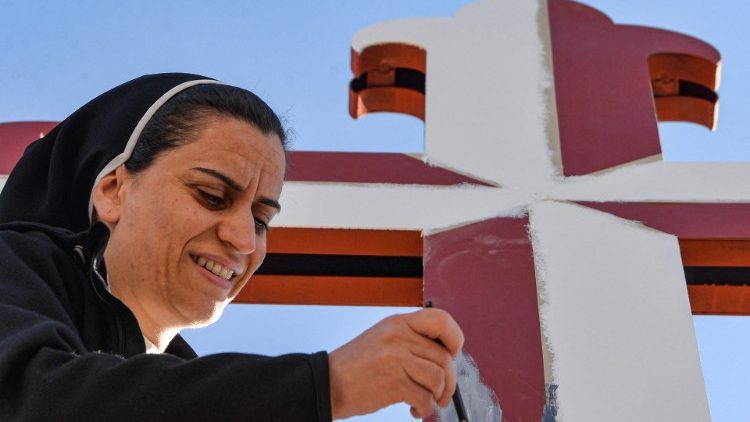 Irak, Karakosch: Eine Ordensschwester verschönert ein Kruzifix für den Papstbesuch