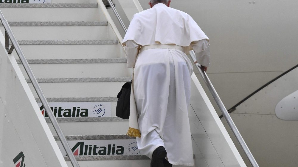 Papa sobre as escadas do avião carregando sua pasta preta
