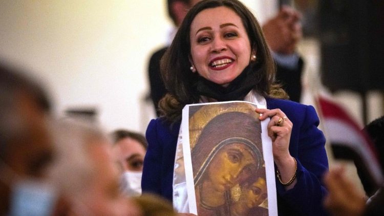 An Iraqi worshipper smiles during the ceremony led by the Pope in Baghdad