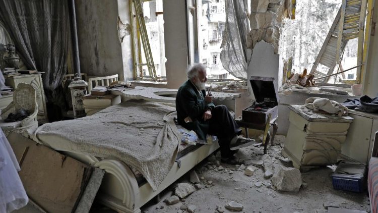 Жител на Алепо сред развалините на дома си.