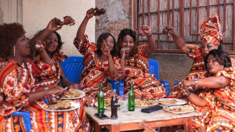 Women wearing the same dress pose for pictures as they commemorate the International Women's Day on March 8, 2021, in Bujumbura