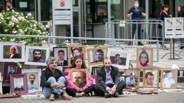 Aktivisten vor Bildern von Opfern des syrischen Regimes, während eines Protests im Juli 2020 vor dem Prozess gegen zwei syrische mutmaßliche ehemalige Geheimdienstler in Koblenz.