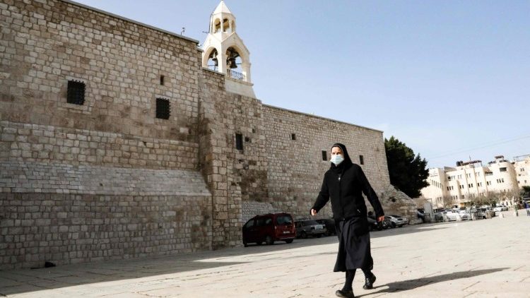 Eine Ordensfrau mit Gesichtsmaske vor der Geburtskirche in Bethlehem
