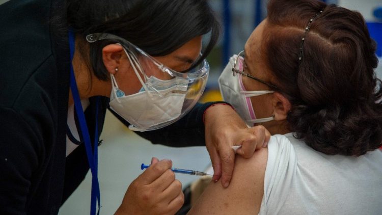 Una enfermera en México aplica una vacuna a una mujer de la tercera edad