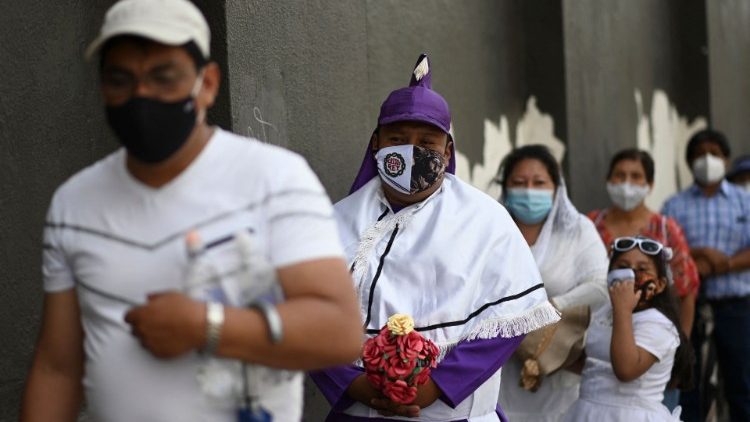 Devotos católicos con mascarillas contra la propagación del nuevo coronavirus, COVID-19, hacen fila en la Iglesia de la Candelaria durante las celebraciones de Semana Santa, en Ciudad de Guatemala, el 1 de abril de 2021.