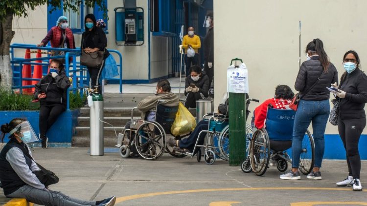 People await to receive medical attention outside the emergency area at a Hospital in Lima