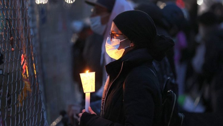 A woman holds a candle at a vigil outside a police station near Minneapolis