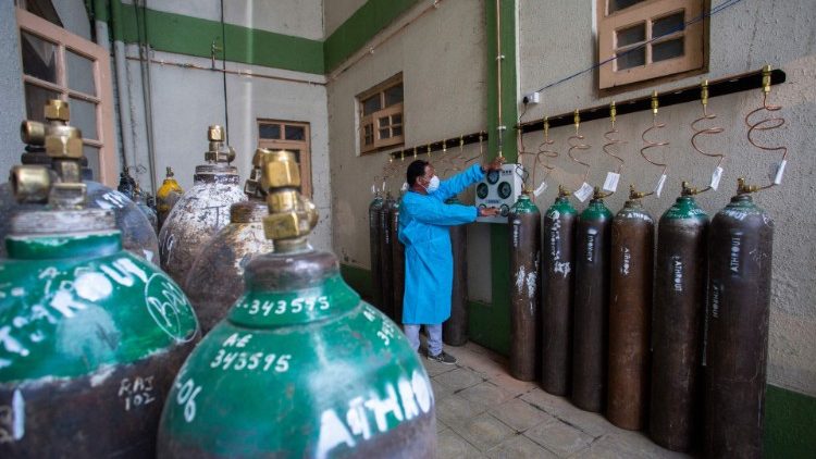 Un travailleur sanitaire remplit des bouteilles d'oxygène qui font cruellement défaut en ce moment en Inde