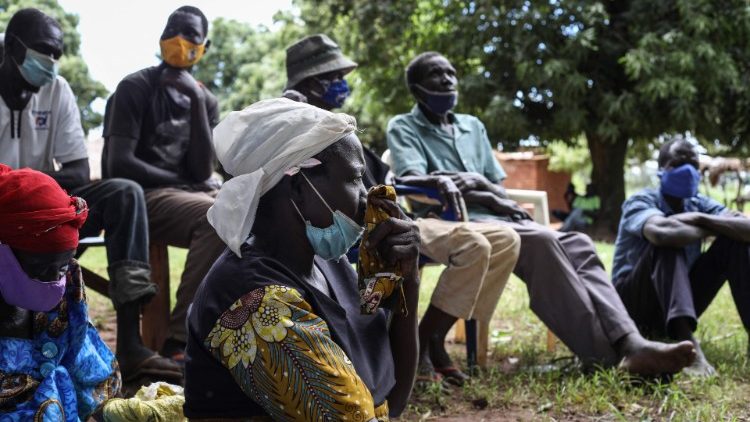 Einwohner des Dorfes Lukodi hören einer Radio-Sendung zu