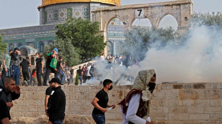 Palestinian protesters run for cover from tear gas near al-Aqsa Mosque