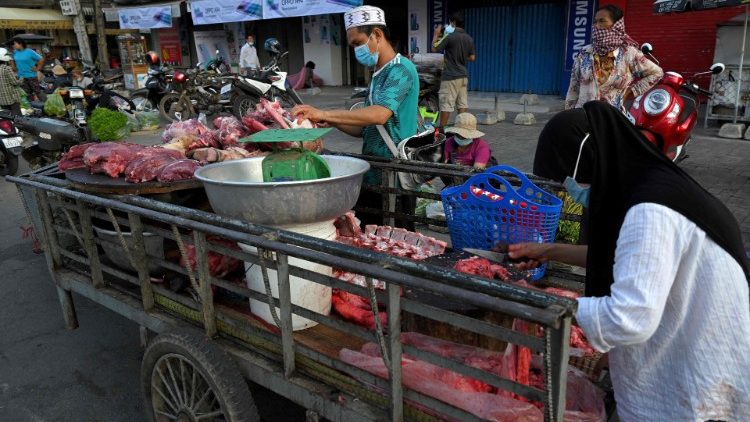 Vendedores preparam carne para venda ao longo de uma rua enquanto os mercados permaneciam fechados em meio a restrições de bloqueio introduzidas para tentar impedir um aumento de casos do coronavírus Covid-19 em Phnom Penh em 11 de maio de 2021. (Foto por TANG CHHIN Sothy / AFP)